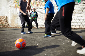 Menschen spiele Fußball, von den meisten sieht man nur die Beine. Foto: David Mauer