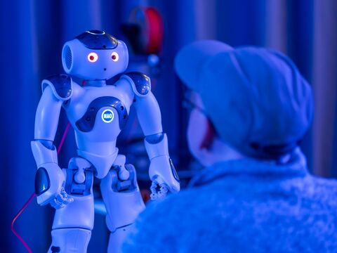 Person mit Basecap betrachtet Roboter (Foto: Dennis Lenz)