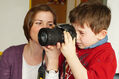 Kind schaut durch eine Kamera, unterstützt von einer Frau (Foto: C. Müller-Zurek)