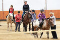 Kinder und Jugendliche auf Pferden in der Reithalle